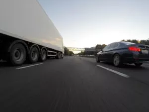 car-driving-along-side-semi-truck