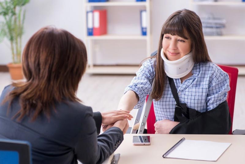 injured woman with neck brace talking to pi lawyer