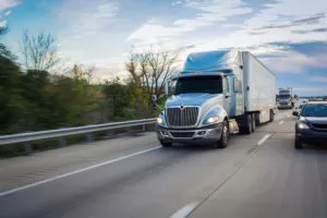 Passenger cars driving safely around large trucks in Houston.